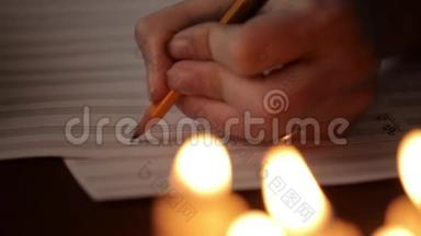 学生写音乐：音乐家用铅笔在音乐书中作曲。 音乐人员